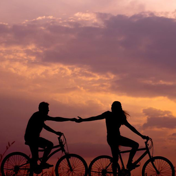 lifelab_relatie_coaching-silhouette-fietsers-wolken-roze-zonsondergang